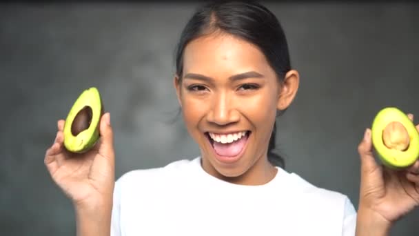 Retrato Una Hermosa Joven Sonriente Camiseta Blanca Sosteniendo Mitades Aguacate — Vídeo de stock