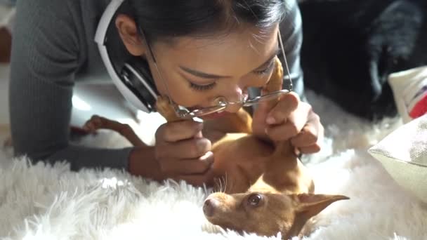 Όμορφη Χαμογελαστή Κορίτσι Ακουστικά Χαλαρωτικό Σκυλί Της Ένα Κρεβάτι Στο — Αρχείο Βίντεο