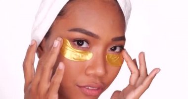 Beyaz arka plan üzerinde izole kollajen pedleri altın göz maskesi kullanarak temiz bir cilde sahip güzel gülümseyen bir kadının yakın çekim portresi. Güzellik bakımları ve kozmetik spa terapi konsepti