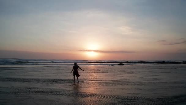 아름다운 일몰에 해변에서 여자의 실루엣입니다 해변에서 휴식을 취하는 — 비디오