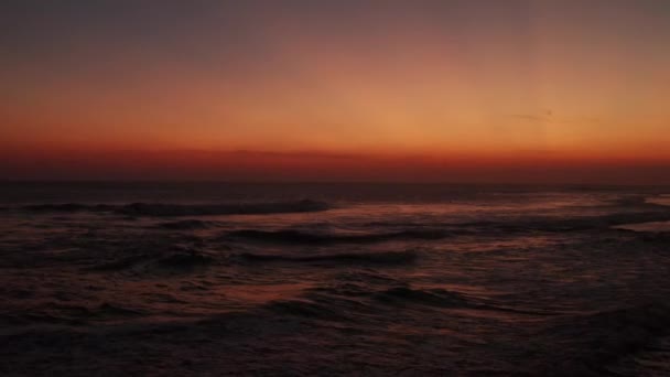 美しい黄金の夕日の空の背景にサーフィンの人々の空中ドローンビューのシルエット — ストック動画
