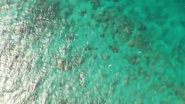具有珊瑚礁和阳光的水晶般清澈的泻湖海水表面的空中无人机顶视图 — 图库视频影像