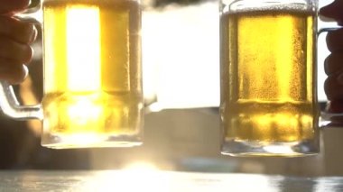 Sıcak yaz gününde güneş ışınları ile taze bira bira bardak bardak clinking Closeup tost - yavaş çekimvideo