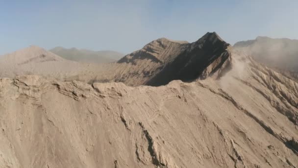 東ジャワ インドネシアの活火山煙とブロモ山のクレーターエッジの空中ビューを撮影した映画ドローン — ストック動画