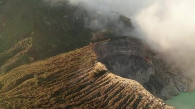 Gün doğumunda Ijen yanardağı ve gölü yakınlarındaki bulutlar ile güzel volkanik manzara havadan drone görünümü, Endonezya