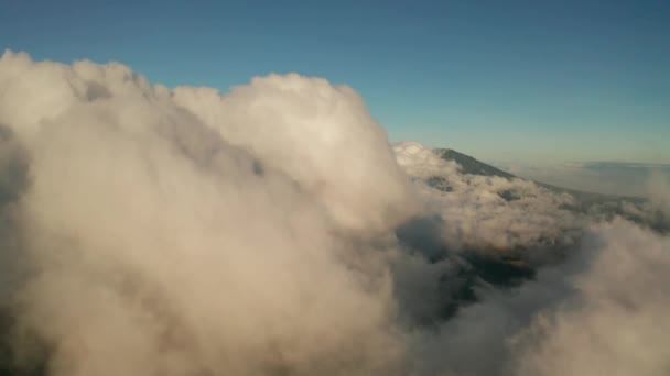 日の出時のイジェン火山と湖の近くに雲で覆われた美しい山々の風景の空中ドローンビュー インドネシア — ストック動画