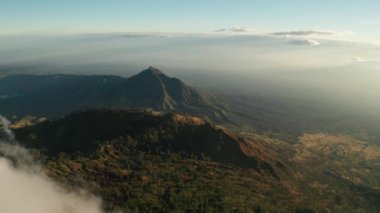 Gün doğumunda Ijen yanardağı ve gölü yakınlarındaki bulutlar ile güzel volkanik manzara havadan drone görünümü, Endonezya