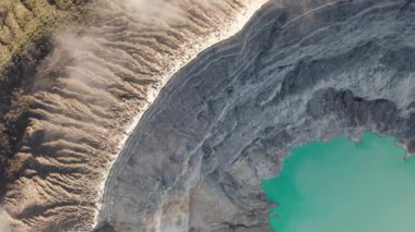 Ijen yanardağı yakınlarındaki bulutlar ile güzel volkanik manzara ve asit gölü havadan drone üst görünümü, Endonezya