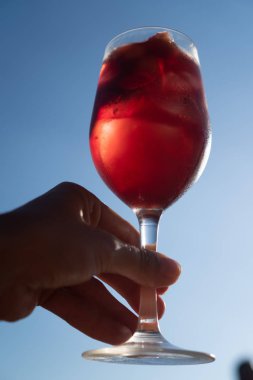 El mavi yaz gökyüzü üzerinde izole bir bardak kırmızı şarap ile Sangria hizmet