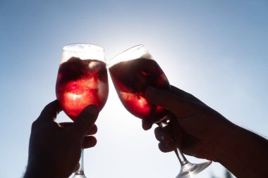 Kırmızı şarapile Sangria kadehleri ile tost elleri closeup. Yaz, tatil, parti konsepti