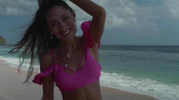 ピンクのビキニ遊びで美しい日焼けしたフィットネス女性 ビーチで自由な時間を過ごす — ストック動画