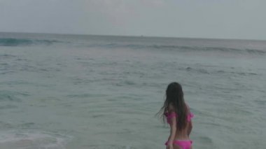 Pembe bikini oynayan güzel tabaklanmış fitness kadın, plajda serbest zaman harcama - yavaş hareket video