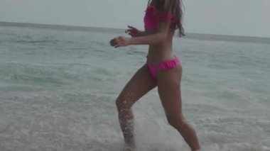 Pembe bikini oynayan güzel tabaklanmış fitness kadın, plajda serbest zaman harcama - yavaş hareket video