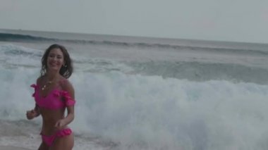 Pembe bikini oynayan güzel tabaklanmış fitness kadın, plajda serbest zaman harcama - yavaş hareket video