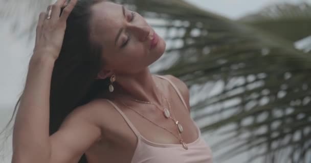 ビーチでポーズビキニで美しい日焼けしたフィットネス女性 スローモーションでビデオ — ストック動画