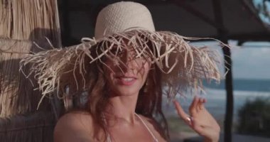 Plaja yakın bikini ve hasır şapka güzel tabaklanmış kadının closeup yüzü - yavaş çekimvideo