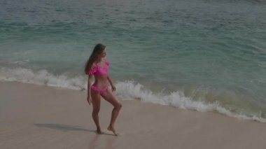Pembe bikini güzel tabaklanmış fitness kadın plajda serbest zaman harcama - yavaş hareket video