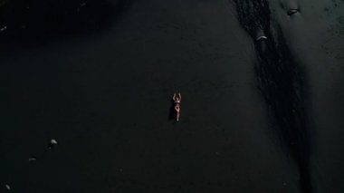 Siyah pırıl pırıl kum plajda poz bikini güzel şehvetli kadın Top havadan drone görünümü