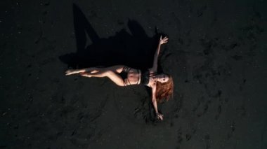 Siyah pırıl pırıl kum plajda poz bikini güzel şehvetli kadın Top havadan drone görünümü