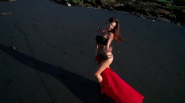 Siyah pırıl pırıl kum plajda poz bikini ve kırmızı genel güzel şehvetli kadın havadan drone görünümü