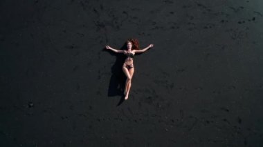 Siyah pırıl pırıl kum plajda poz bikini güzel şehvetli kadın Top havadan drone görünümü