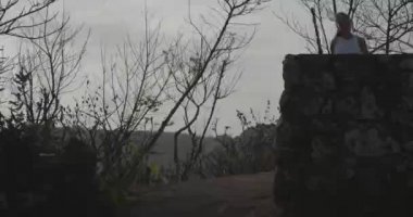 Genç çekici kadın gün doğumunda deniz kıyısında uçurumda koşu