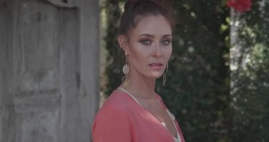 Ahşap kapı kapısının yanında çiçeklerle bahçede poz veren güzel kadın