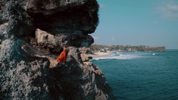 Güneşli Yaz Gününde Deniz Kıyısındaki Kayalıkta Poz Veren Kırmızı Elbiseli — Stok video