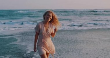 Güneşli yaz günü boyunca kumlu plajda rahatlatıcı elbise Pretty mutlu kız - yavaş hareket video