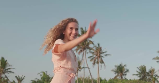 晴れた夏の日に熱帯のビーチでリラックスドレスでかなり幸せな女の子 スローモーションでビデオ — ストック動画