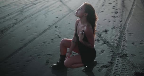 Sensual Menina Morena Vestido Preto Botas Posando Praia Areia Preta — Vídeo de Stock