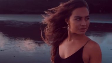 Siyah kum plajda poz siyah elbise şehvetli esmer kız Portresi - yavaş hareket video