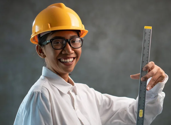 有吸引力的亚洲女工程师的肖像与建筑水平在混凝土墙背景 — 图库照片
