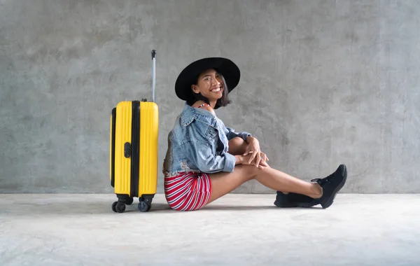 微笑的亚洲年轻女子的肖像与行李隔离在混凝土墙背景 人的生活方式 旅游理念 — 图库照片