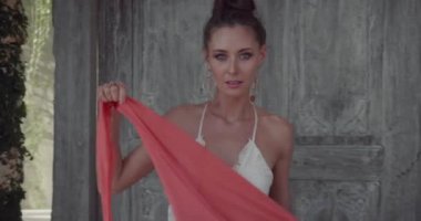 Ahşap kapı kapısı yakınında çiçeklerle bahçede poz güzel kadın Portresi - yavaş hareket video