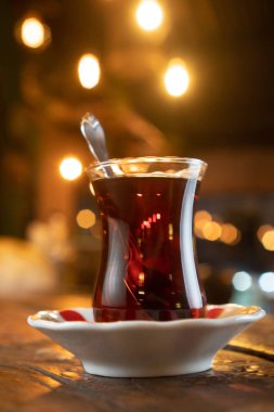 Kırsal ahşap masada kaşıkla bir bardak Türk çayı.