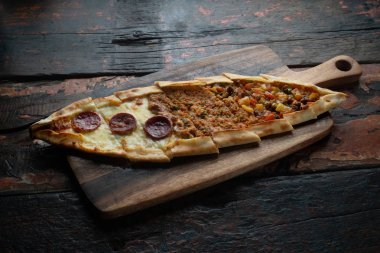 Köy ahşap masasında yalıtılmış sosis, biftek ve sebzeli Türk pidesi