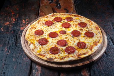 Köy ahşap arka planda izole edilmiş Türk sosisi ve mozzarella peynirli taze lezzetli pizza.