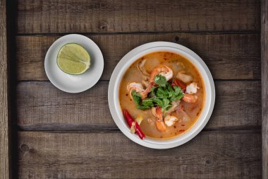 Üst düzey Tayland yemekleri Tom Yum çorbası karidesli ve sade ahşap masa.