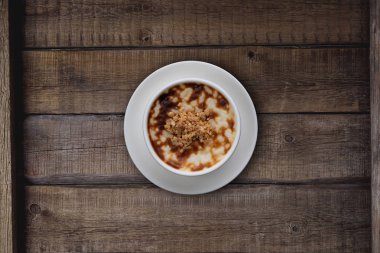 Köy ahşap masa üzerinde cevizli geleneksel pirinç pudinginin üst görüntüsü.