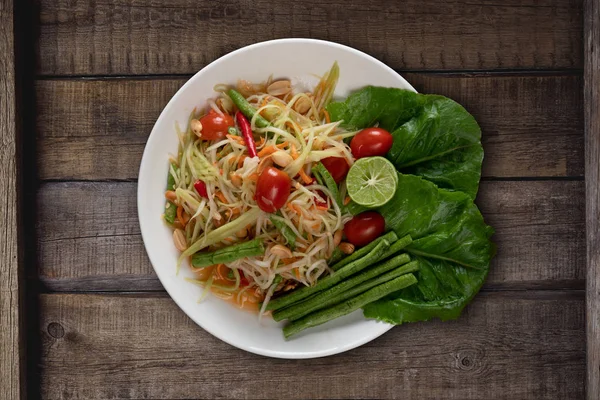 Top view Thai food rice noodle papaya salad isolated on wooden table