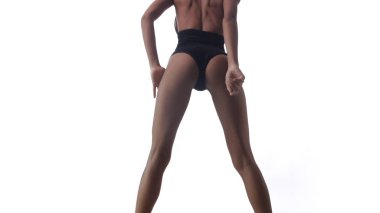 Beyaz duvar arkasında poz veren siyah elbiseli güzel bir kadın.