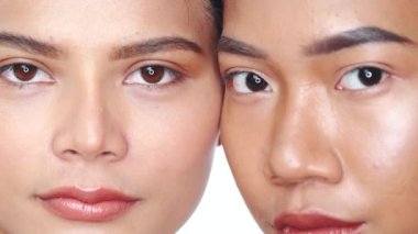 İki güzel Asyalı kadının beyaz arka plandan kameraya bakışları. Doğal güzellik. Cilt bakımı kozmetikleri