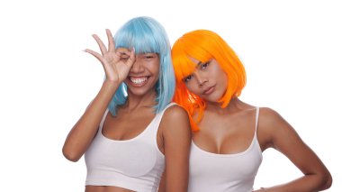 Parlak mavi ve turuncu peruklu iki güzel Asyalı kadının portresi beyaz arka planda poz veriyor.