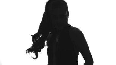 Beyaz arka planda dans eden bir kadının silüeti.