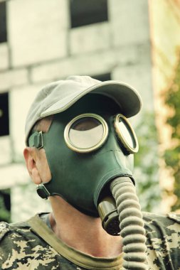 Gaz maskesi ve kap closeup tahrip kentsel arka plan erkekler. 