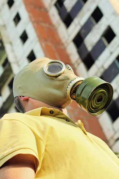 Persoon in gasmasker op vernietigde bouw achtergrond. — Stockfoto