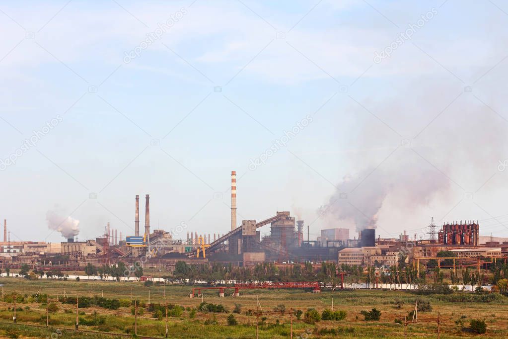 Large industrial plant with smoking factory chimneys on blue sky