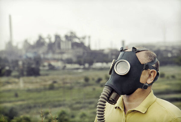 Men wearing gas mask on industrial factory background.