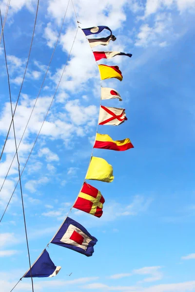 Сигнальні прапори на щоглі на блакитному хмарному небі . — стокове фото